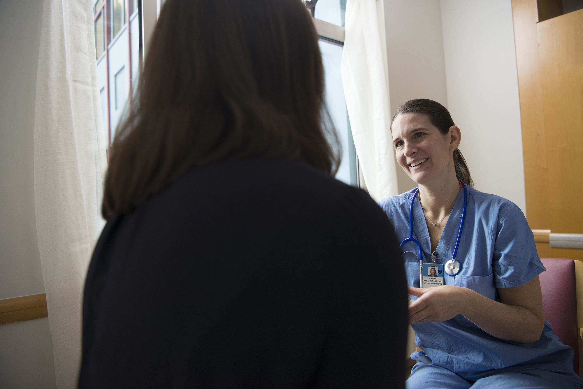 Tufts Medical Center's Director of Women's Care and Obstetrician and Gynecologist, Laura Baecher-Lind, MD, MPH, talks with a patient. 