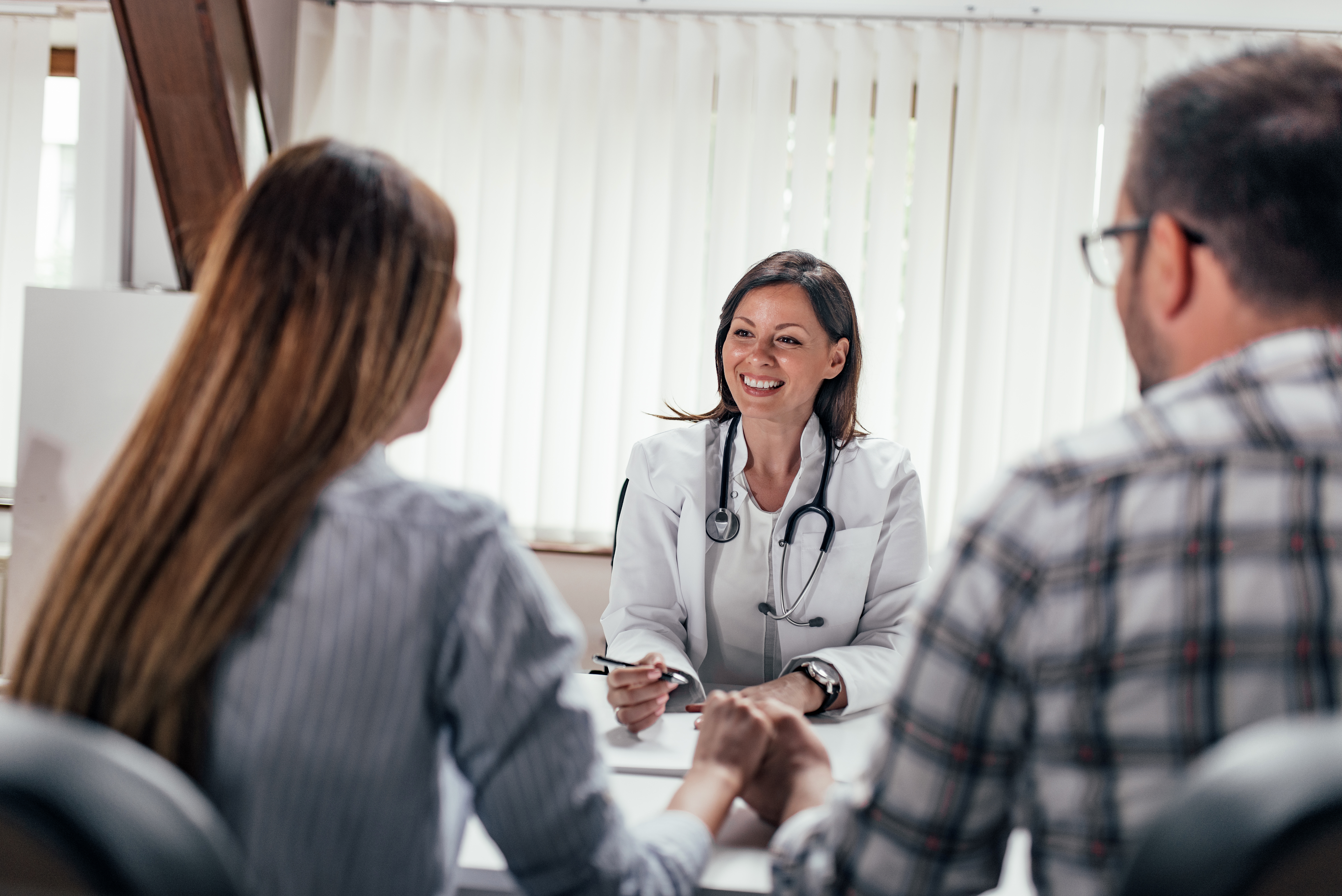 Doctor speaking with a couple during a sexual health appointment