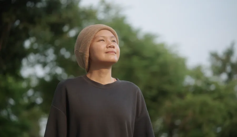 Person wearing a hat looking at the sky