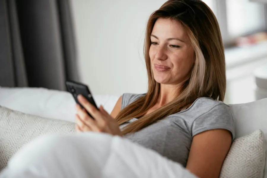 Woman on a couch looking at her phone