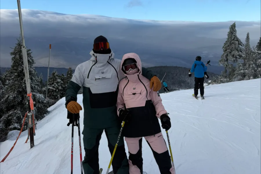 Two people on a mountain skiing