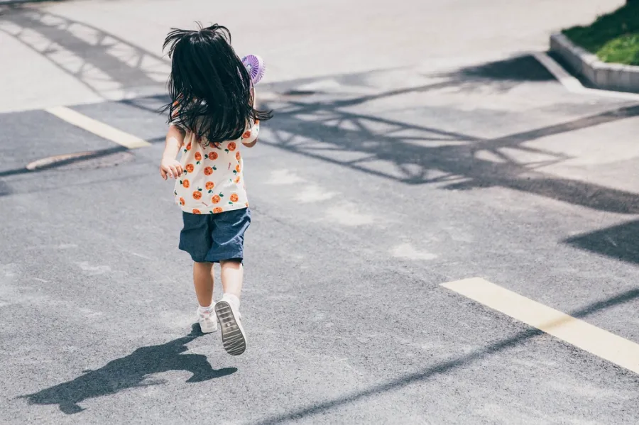 A young child crossing the street