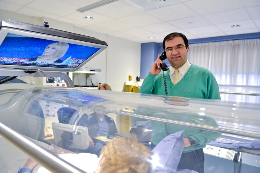 Payam Salehi, MD speaking with a patient receiving hyperbaric oxygen therapy