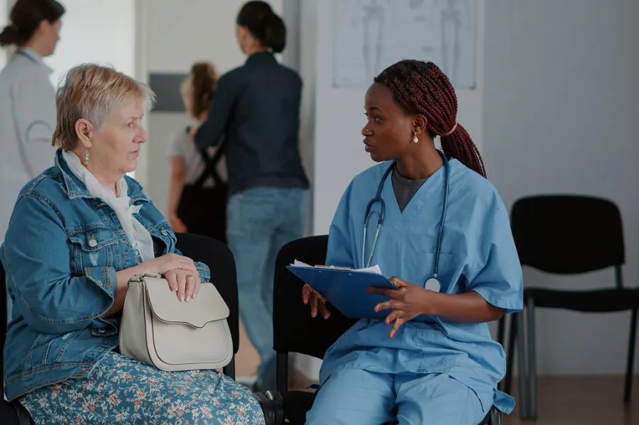 A clinician speaking with a patient in a medical clinic