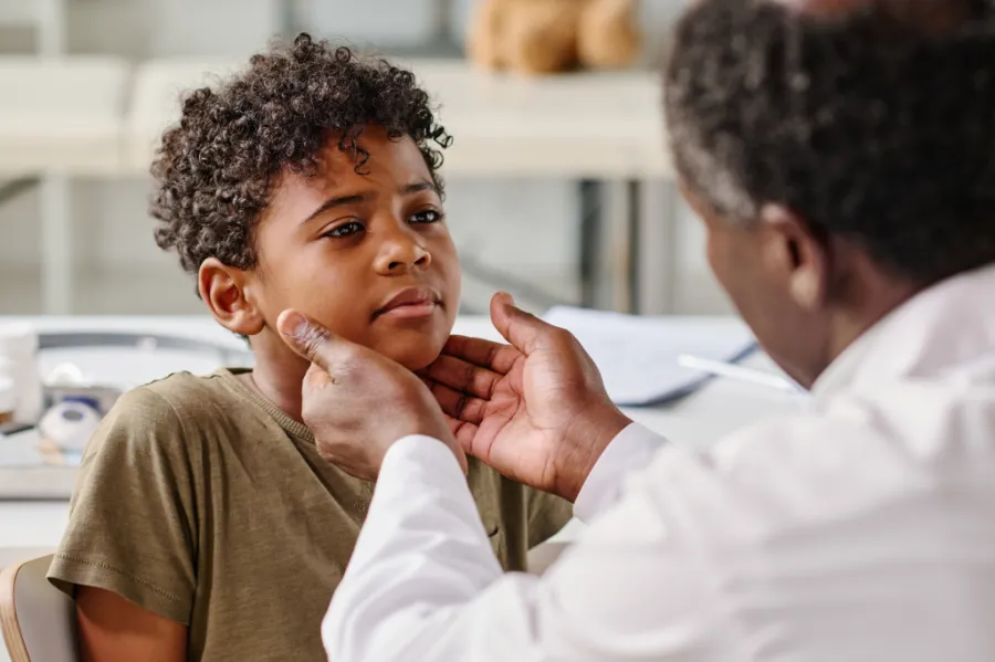 Doctor performing exam on child's neck