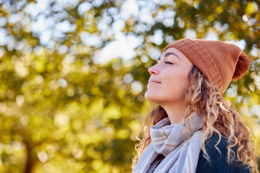 Person taking a deep breath outside in the fall air