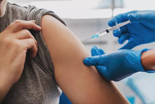 Person receiving needle injection in arm