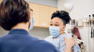 Nurse Tiano Rao comforting patient during an OBGYN Oncology appointment.