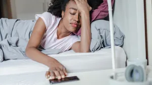 Woman, in bed, distressed from lack of sleep.