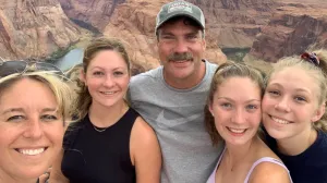 A family smiles while hiking