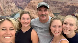 A family smiles while hiking