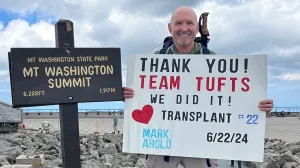 Mark Arold holding a sign at the top of Mt. Washington