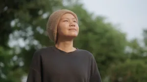 Person wearing a hat looking at the sky