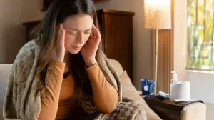 Woman with hands on head, looking like she is sick