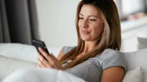 Woman on a couch looking at her phone