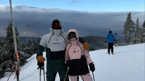 Two people on a mountain skiing