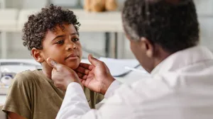 Doctor performing exam on child's neck