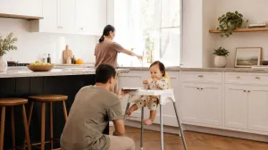 Man feeding baby in highchair
