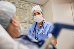 Anesthesiologist Megan Pursley, SRNA comforting patient before surgery. 