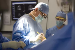 Carl Heilman, MD and Haran Ramachandran, MD in a neurosurgery to remove three benign brain tumors from a patient.