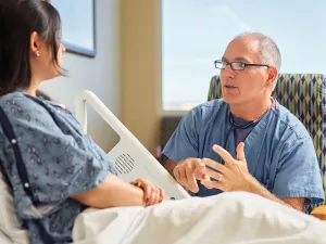 Cardiologist Eric Ewald, MD talks to patient in Lowell General Hospital's Heart and Vascular inpatient unit (D4Med).