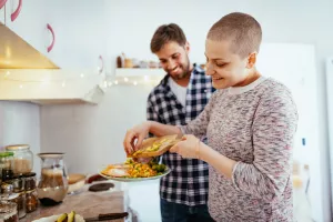 Cancer patient cooking a healthy and nutritious meal at home with their partner.