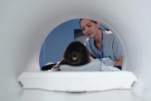 Technician setting up a pediatric patient in an MRI. 