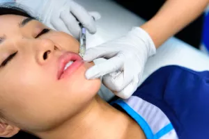 Farah Moustafa, MD, FAAD providing lip augmentation filler to patient in the Cosmetic and Laser Center within Dermatology at Tufts Medical Center.