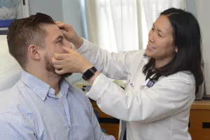 Clarissa Yang, MD, Chief of Dermatology at Tufts Medical Center, examines patient for skin cancer during a clinic appointment.