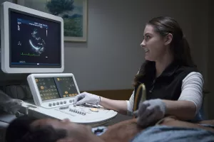 Tufts Medical Center echo lab technician, Kasey Gillis performing a cardiovascular image, echocardiogram, to patient during an appointment.