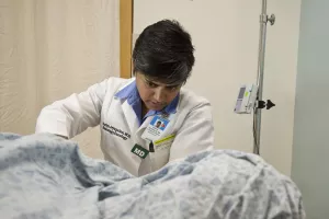 Neuro-oncologist, Suriya Jeyapalan, MD, MPH does a lumbar puncture on patient in preparation for intrathecal chemotherapy at Tufts Medical Center's Cancer Center.