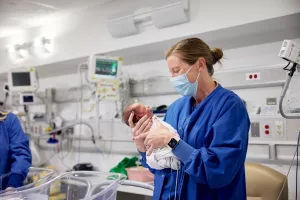 Tracy Garrett, RN holding newborn infant at MelroseWakefield Hospital's special care nursery.