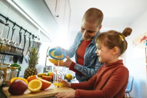 Woman and girl making juice in the kitchen