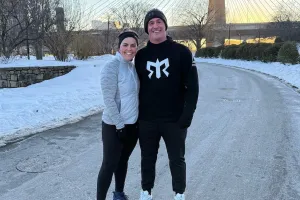Two runners posing by the bridge in Boston