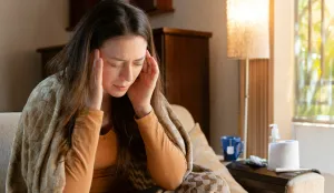 Woman with hands on head, looking like she is sick