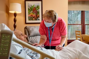 Diane Fumia, RN checking hospice patient's heart with a stethoscope at Care at Home's High Point House.