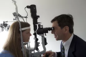 Jay Duker, MD, Ophthalmologist-in-Chief, examining a patient's eyes during an appointment at Tufts Medical Center.