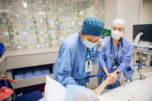Fiona Wu and Megan Pursley, both SRNA Anesthesiologists, prep and comfort patient before daVinci surgery.