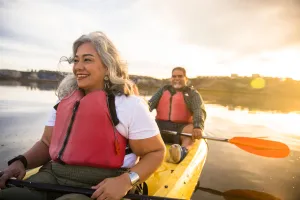 Happy couple kayaking on the water as they incorporate exercise into their weight loss journey.