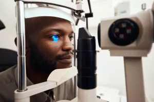 Patient getting their eye’s examined with a slit lamp during an ophthalmology appointment.
