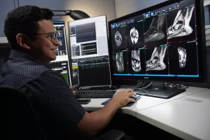 CRA technician at Tufts Medical Center reviewing a radiology imaging scan of a patient's foot.
