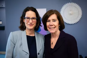 Two female doctors stand, smiling