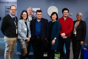 Doctors, investigators and staff pose with smiles