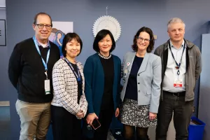 Doctors, investigators and staff pose with smiles