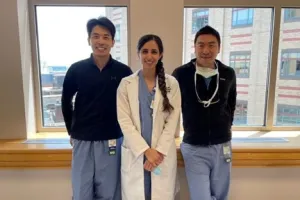 Doctors in scrubs standing by a window, smiling