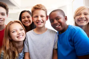 Group of school-age children gathered together indoors.