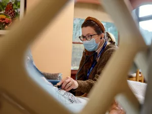 Charlotte Grinberg, MD examining hospice patient's heart with a stethocope at Care at Home's High Pointe House.