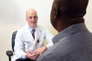 James Krysanski, MD (Chief, Division of Epilepsy Surgery and Co-Chief, Division of Spine Surgery) consults with patient during a clinic appointment.