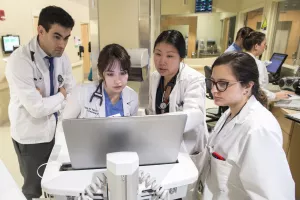 Adam Sudbeck (Neurosurgery PA), Michael Belmont (Medical Student), Nilufer Yalcin, MD (Neurology Resident), Xuemei Cai, MD (Neurocritical Care Attending Physician), Milagros Silva-Colon, MD (Pediatric Neurology Fellow) meeting in an interdisciplinary stroke rounds in the Neurology Critical Care Unit (NCCU) at Tufts Medical Center.