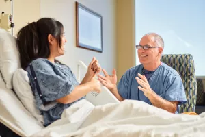 Cardiologist Eric Ewald, MD takes time to laugh and talk with patient in Lowell General Hospital's Heart and Vascular inpatient unit (D4Med).